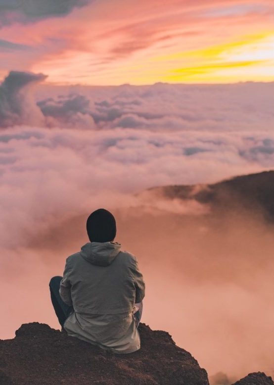 man sitting on cliff